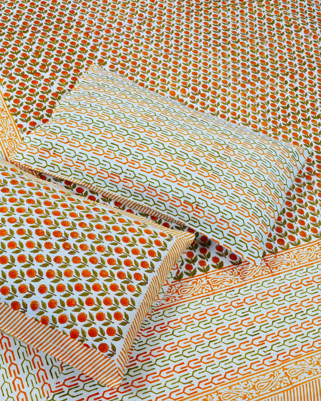 100x108 inch king size cotton bedsheet and matching pillow covers styled with a traditional orange and green floral bud handblock print.