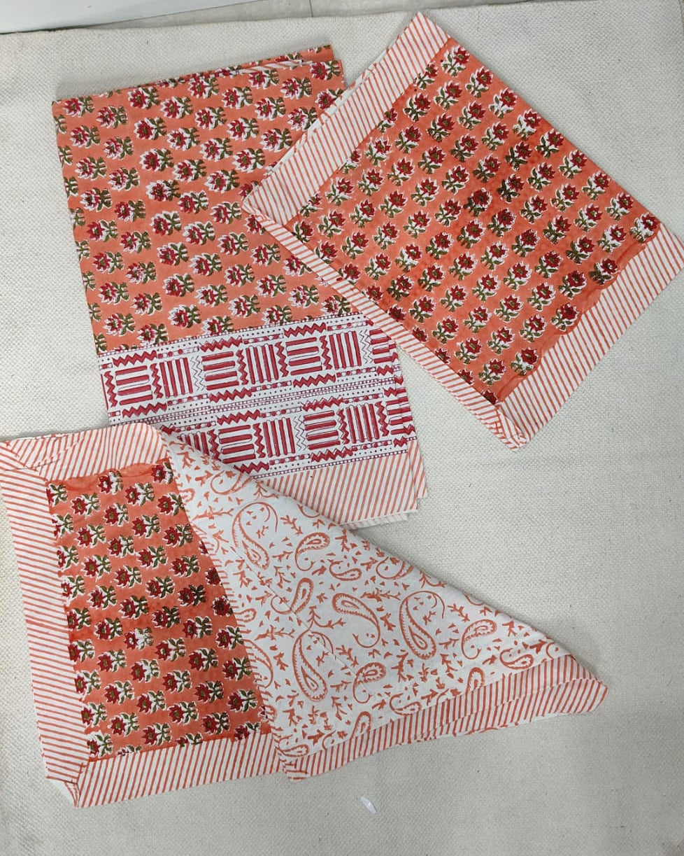 Folded 100x108 inch king size cotton bedsheet and matching pillow covers featuring a traditional orange and white handblock floral and paisley print.