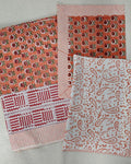 Folded 100x108 inch king size cotton bedsheet and matching pillow covers featuring a traditional orange and white handblock floral and paisley print.