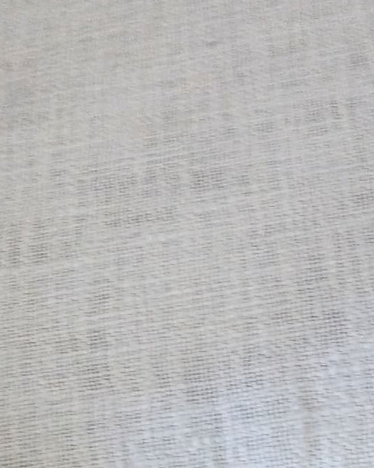 Light sage mint green jute cotton sofa seating cover featuring a vintage floral tapestry patchwork border with fringed tassels on a grey velvet sofa.