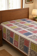 Artisanal patchwork kantha cotton bed sheet and pillow cover set featuring intricate multi-color block-printed panels and traditional hand-stitching.