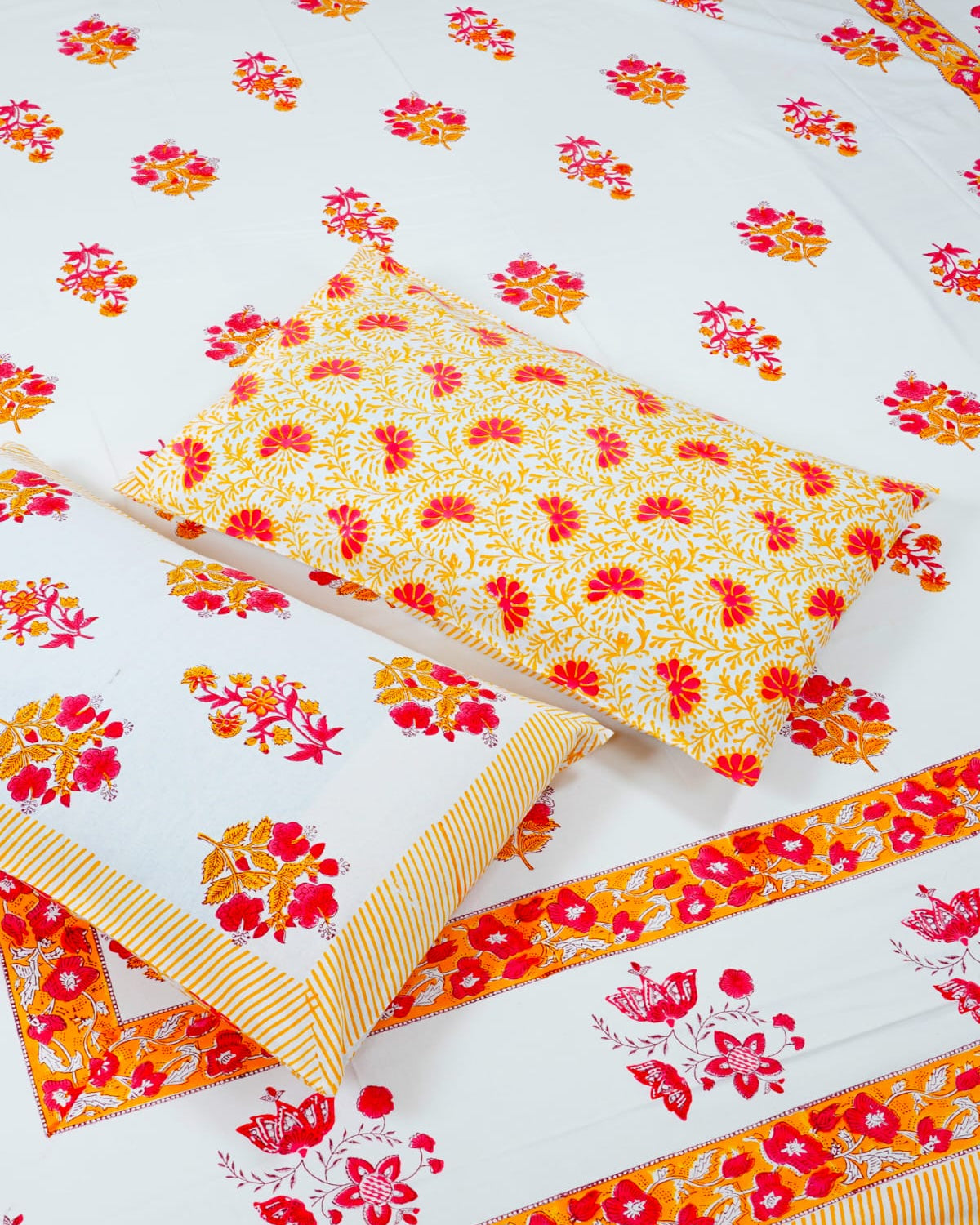 100x108 inch king size cotton bedsheet and matching pillow covers styled with a traditional pink and orange floral handblock print.