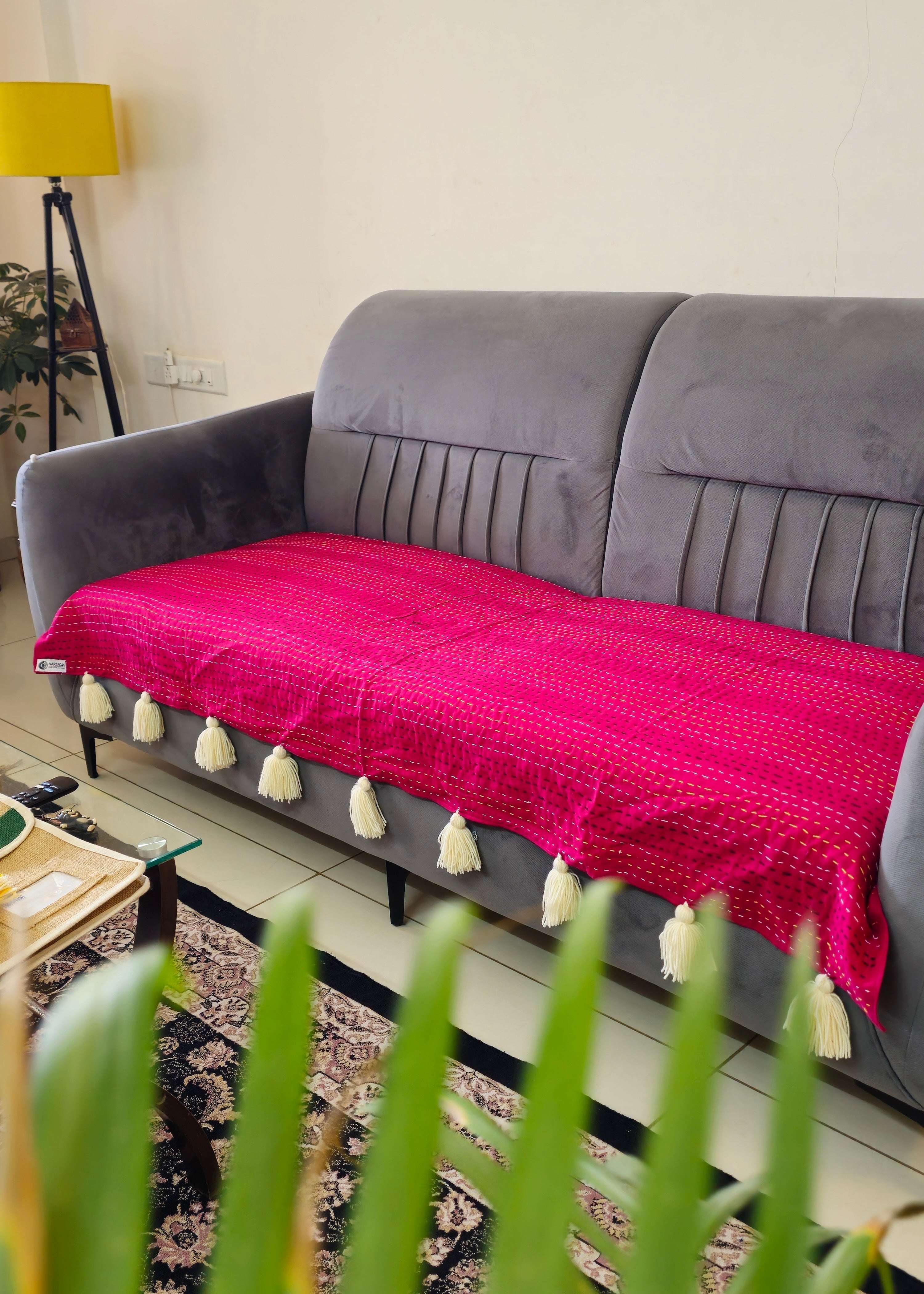 Gray sofa with a pink blanket in a living room setting