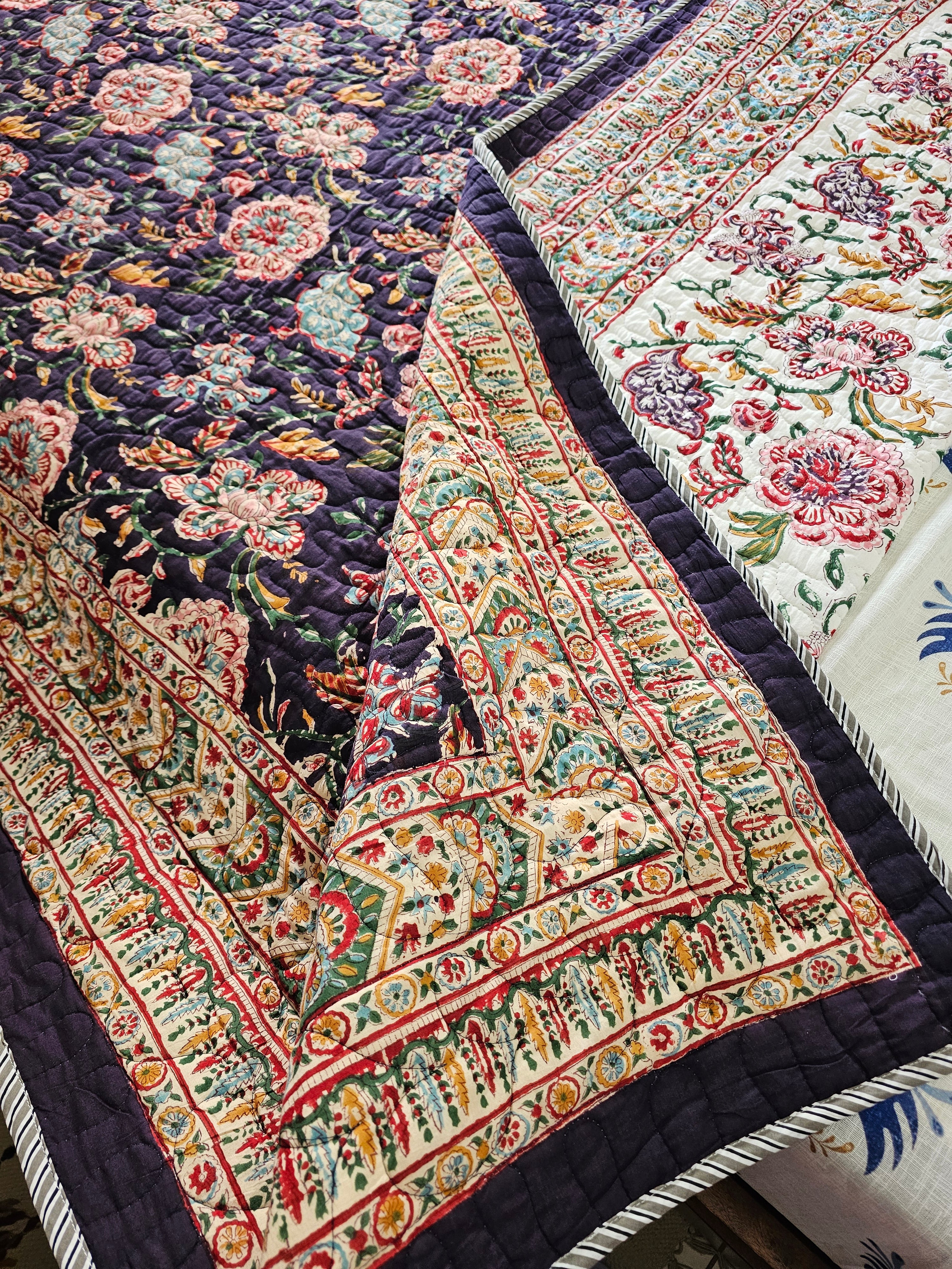 Close-up of patterned quilts with floral and geometric designs.