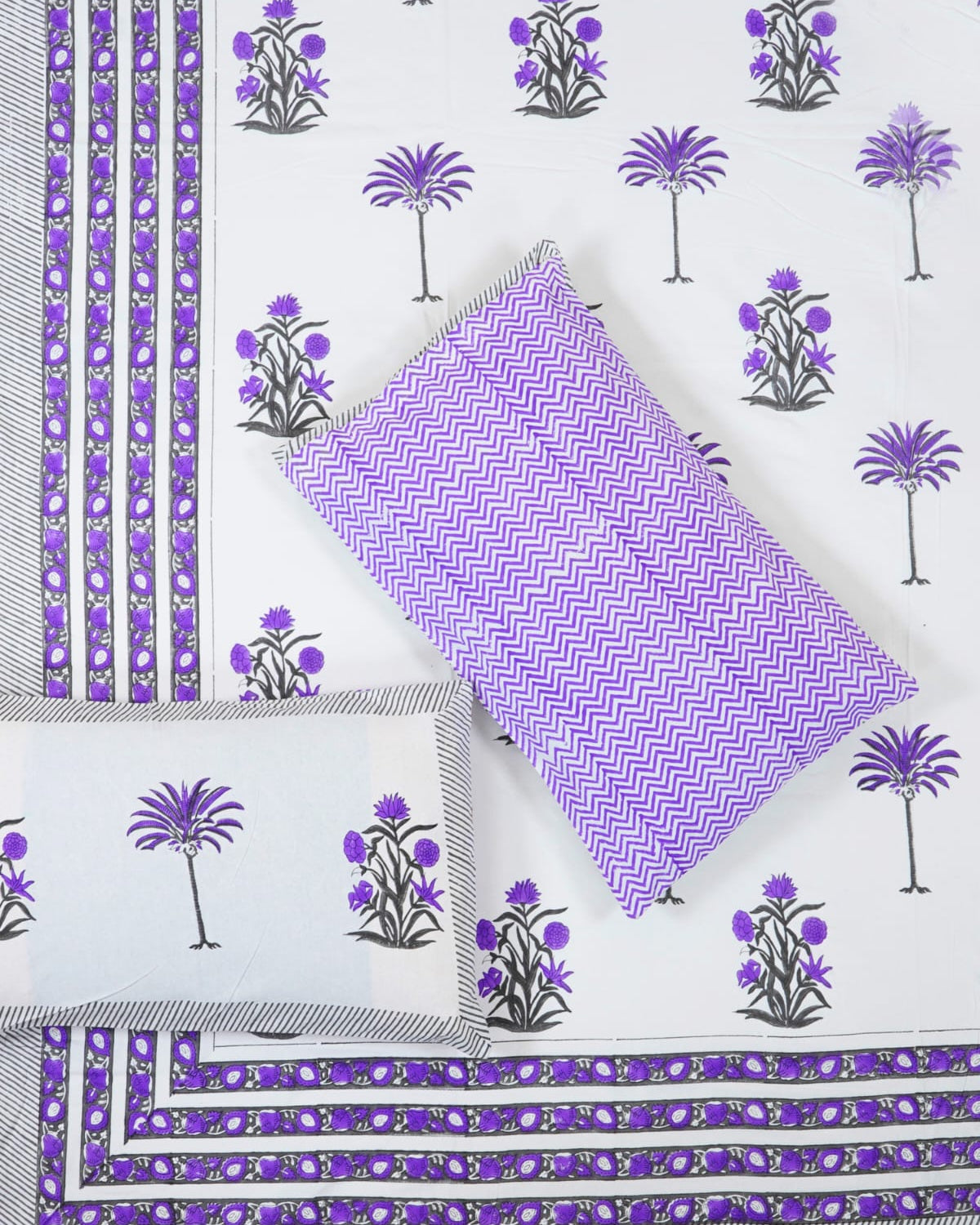 100x108 inch king size cotton bedsheet and matching chevron pillow covers styled with a traditional purple floral and palm tree handblock print.