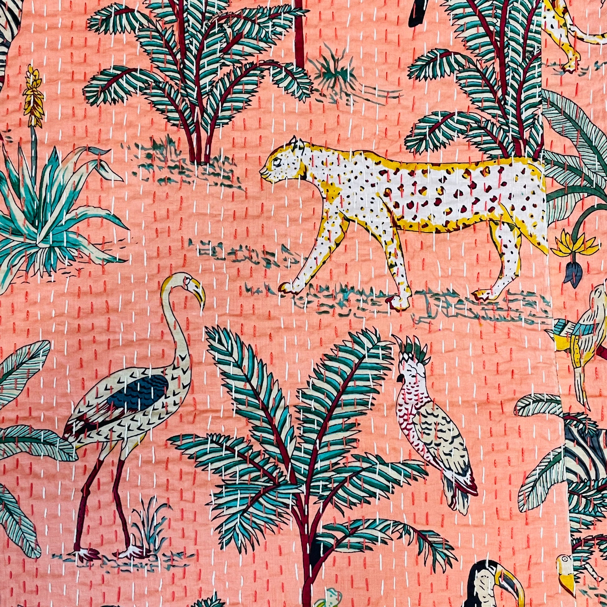 Patterned fabric with leopards, flamingos, and tropical plants on a pink background