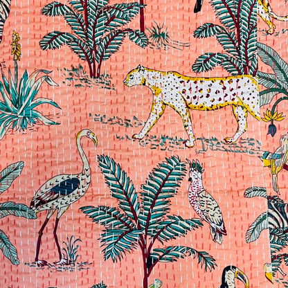 Patterned fabric with leopards, flamingos, and tropical plants on a pink background
