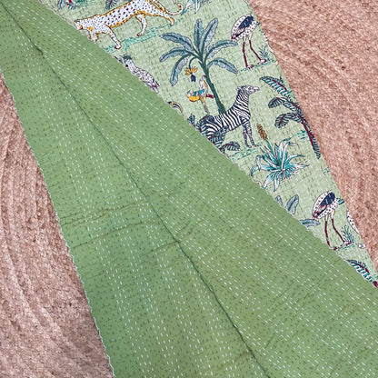 Green fabric with a pattern of animals and plants on a textured surface