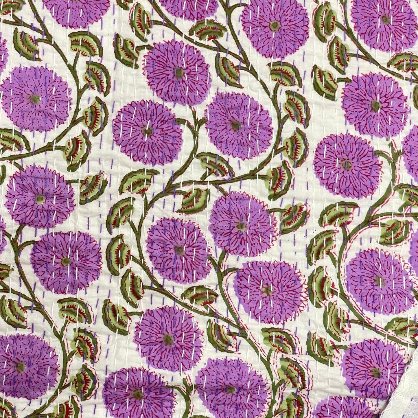 Patterned fabric with purple flowers and green leaves on a white background