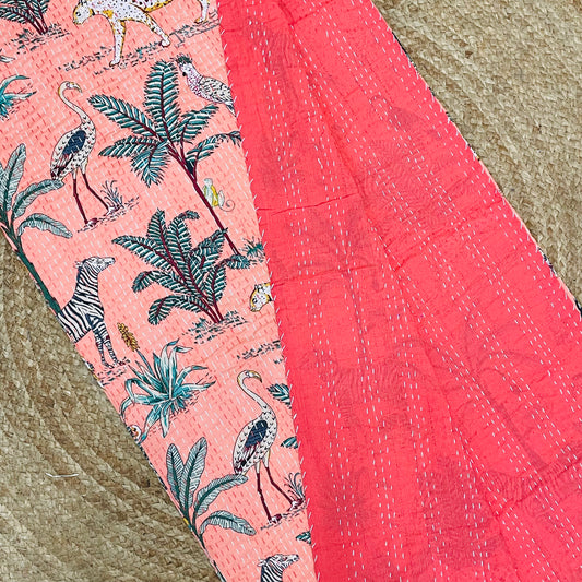 Pink fabric with tropical animal and plant pattern on a textured surface
