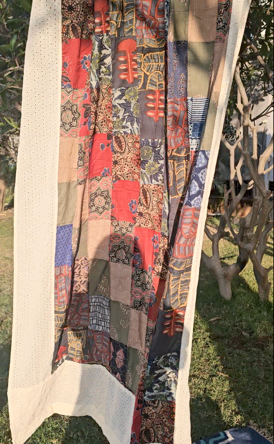 Colorful patterned fabric draped over a wooden frame outdoors.
