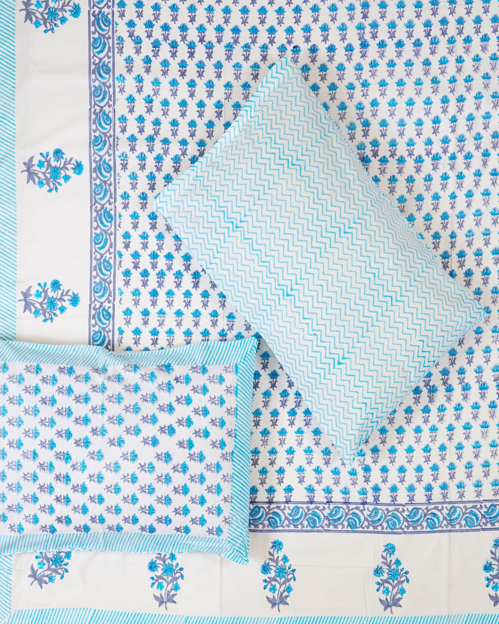 100x108 inch king size cotton bedsheet and matching chevron pillow covers styled with a traditional sky blue and periwinkle floral bud handblock print.