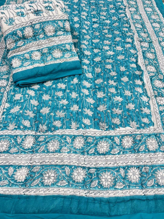 Teal and white floral patterned fabric with a folded piece on top