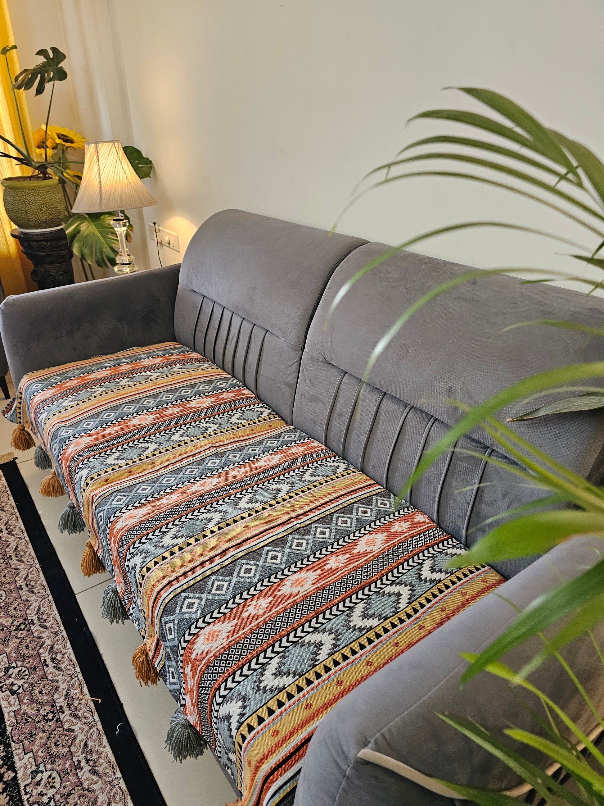 Hanging chair with patterned fabric in a room with plants and a mirror.