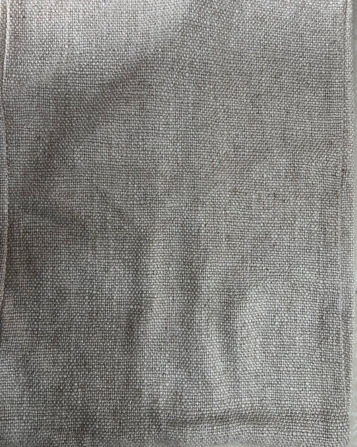 Rectangular solid neutral textured cotton cushion cover in a versatile grey-taupe shade, laid flat on a light surface.