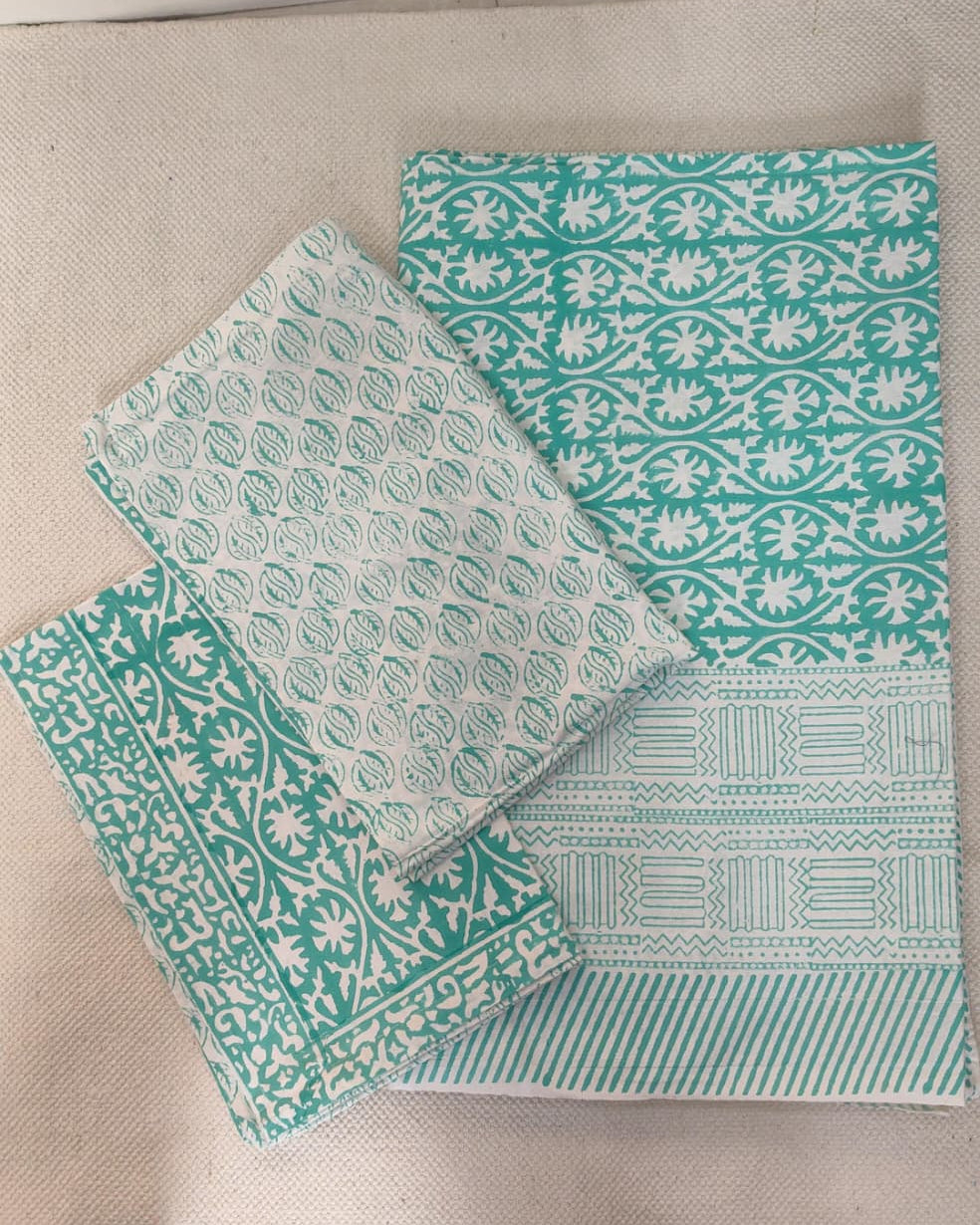 Folded 100x108 inch king size cotton bedsheet and matching pillow covers featuring a traditional teal and white handblock floral print.