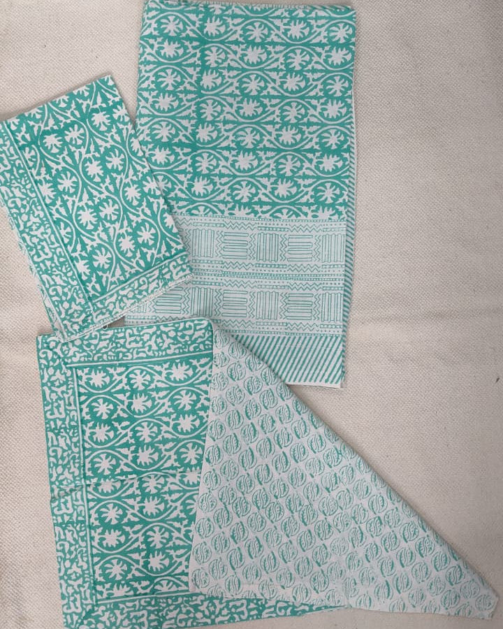 Folded 100x108 inch king size cotton bedsheet and matching pillow covers featuring a traditional teal and white handblock floral print.