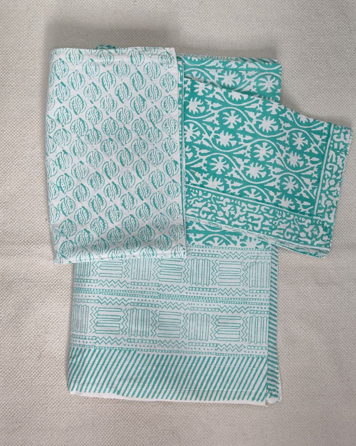 Folded 100x108 inch king size cotton bedsheet and matching pillow covers featuring a traditional teal and white handblock floral print.