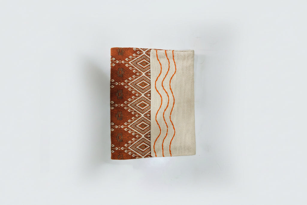 Terracotta Ikat Jacquard Jute Cotton Laptop Sleeve featuring a rust orange diamond geometric pattern and off-white jute panel with orange hand-stitched wave embroidery