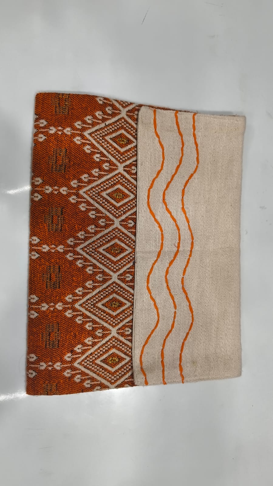 Terracotta Ikat Jacquard Jute Cotton Laptop Sleeve featuring a rust orange diamond geometric pattern and off-white jute panel with orange hand-stitched wave embroidery