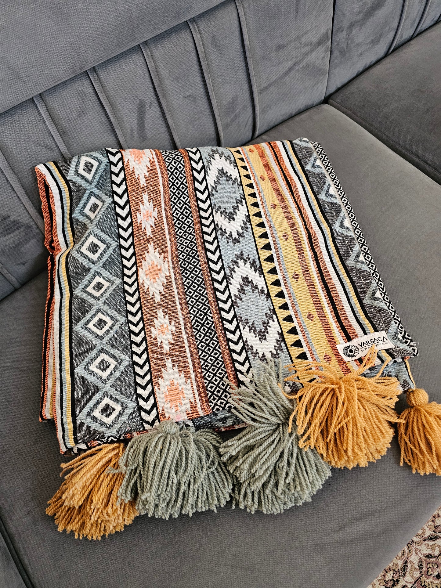 Patterned pouch with tassels on a gray surface