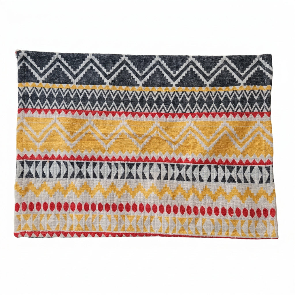 Rectangular woven cotton placemat with a mustard yellow, charcoal black, and red tribal chevron geometric pattern laid flat.