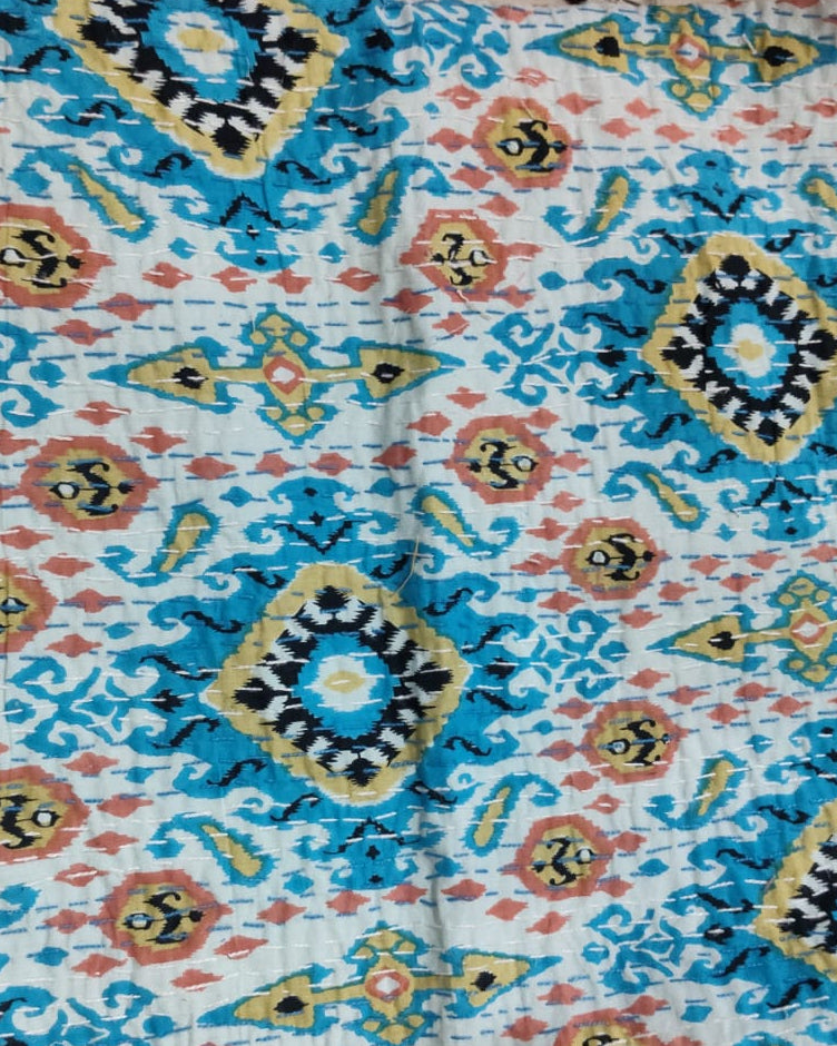 Square cotton cushion cover featuring a turquoise blue and mustard yellow Ikat medallion print with delicate hand embroidery.
