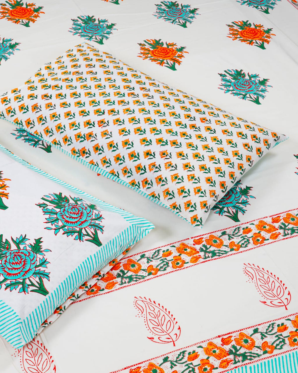 100x108 inch king size cotton bedsheet and matching pillow covers styled with a traditional turquoise and orange floral and paisley handblock print.