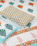 100x108 inch king size cotton bedsheet and matching pillow covers styled with a traditional turquoise and orange floral and paisley handblock print.