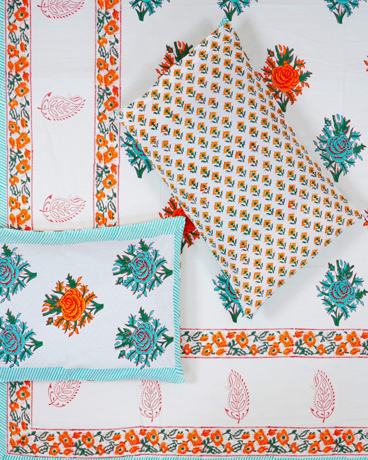 100x108 inch king size cotton bedsheet and matching pillow covers styled with a traditional turquoise and orange floral and paisley handblock print.