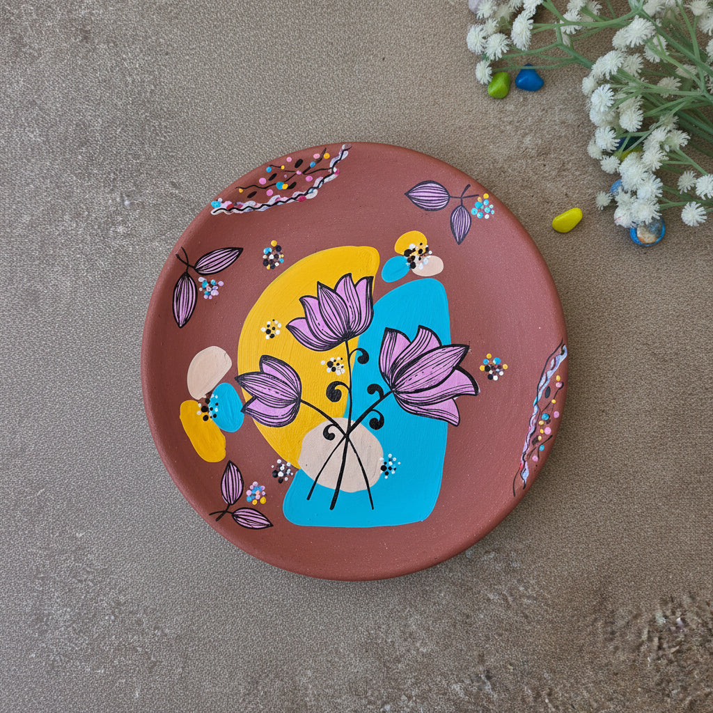Hand-painted terracotta decorative plate featuring three purple lotus flowers over yellow and turquoise abstract shapes.