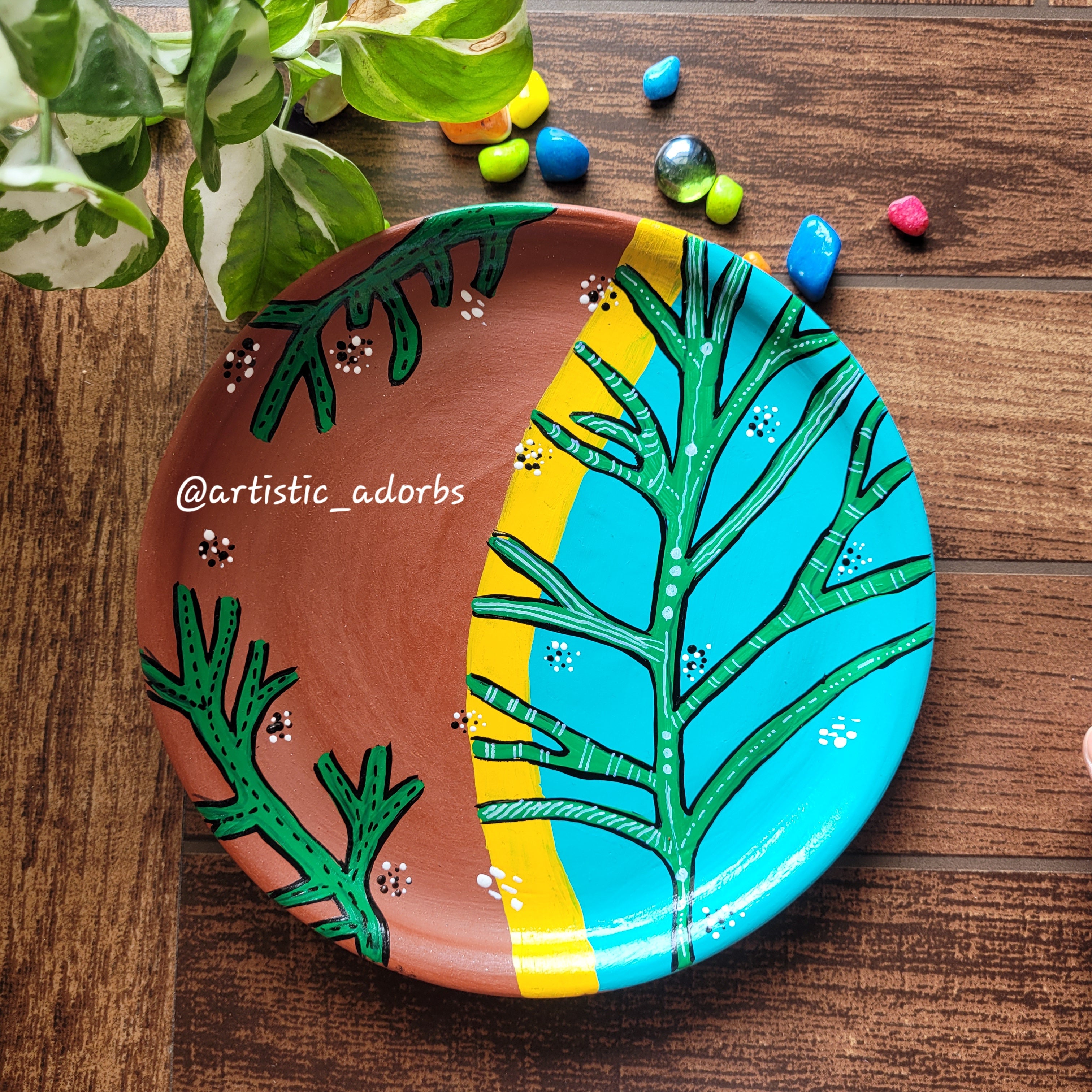 A striking split-palette layout showcasing a vibrant turquoise half with green branching fronds against raw terracotta.