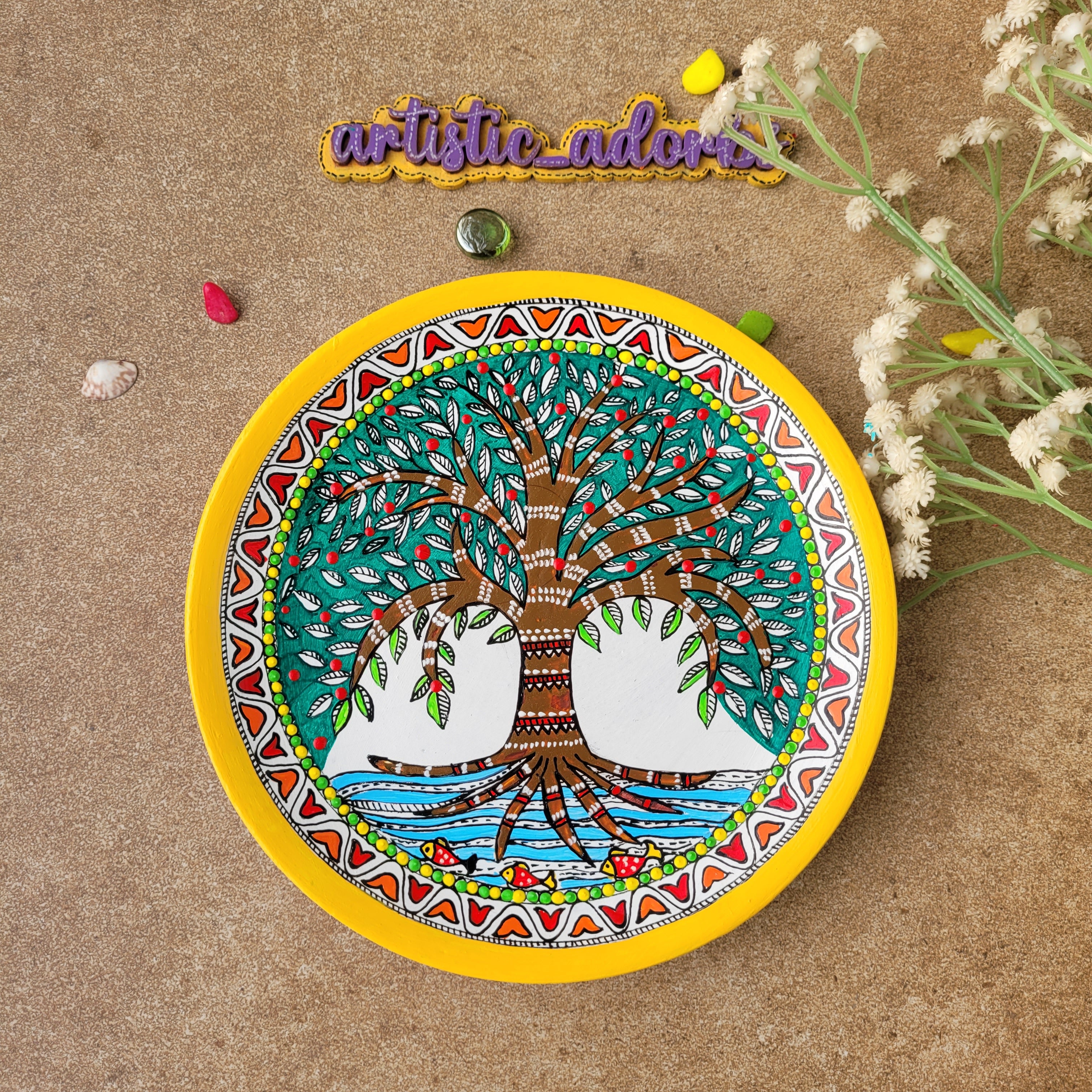 Hand-painted Madhubani terracotta wall plate featuring the Tree of Abundance motif in traditional Mithila art style with a vibrant yellow rim.