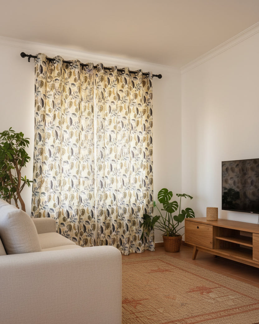 Living room with patterned curtains, sofa, and TV.
