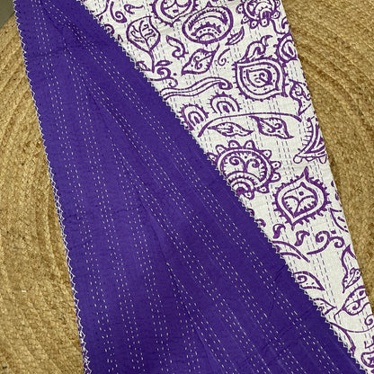 Purple fabric with white paisley pattern on a textured surface