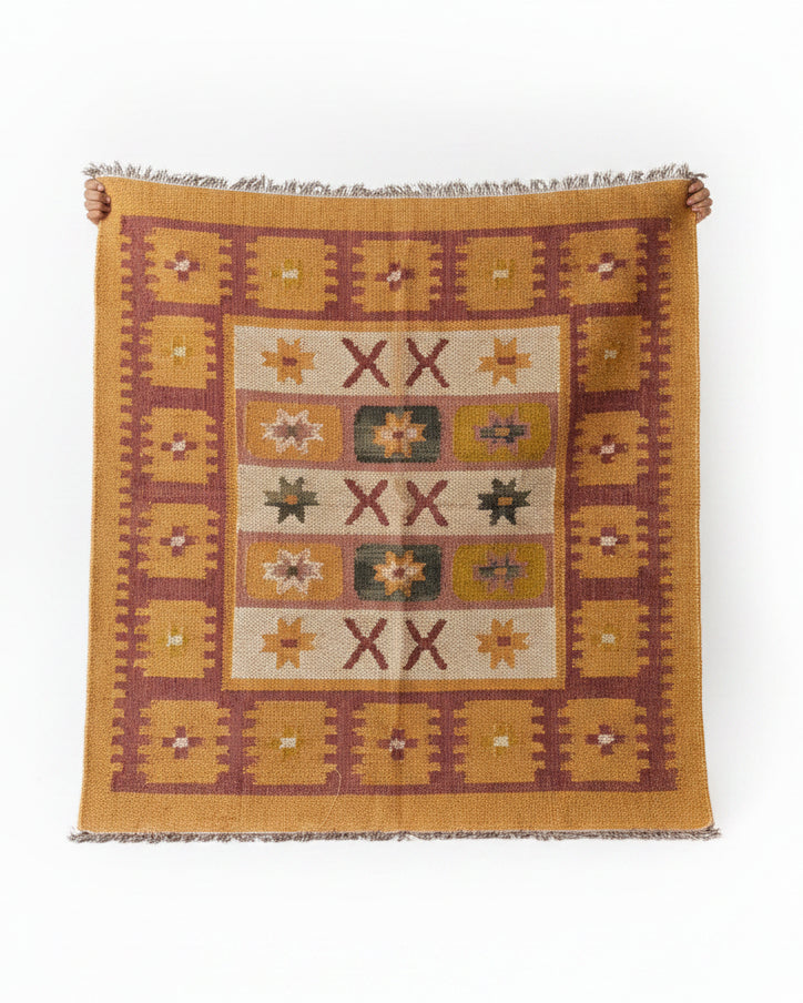 Vasaca handwoven woollen kilim area rug featuring tribal geometric star and cross patterns in ochre yellow and rust brown.
