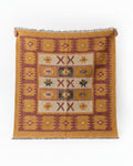 Vasaca handwoven woollen kilim area rug featuring tribal geometric star and cross patterns in ochre yellow and rust brown.