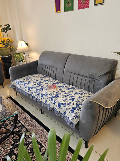 Gray sofa with a floral-patterned cover in a living room setting.