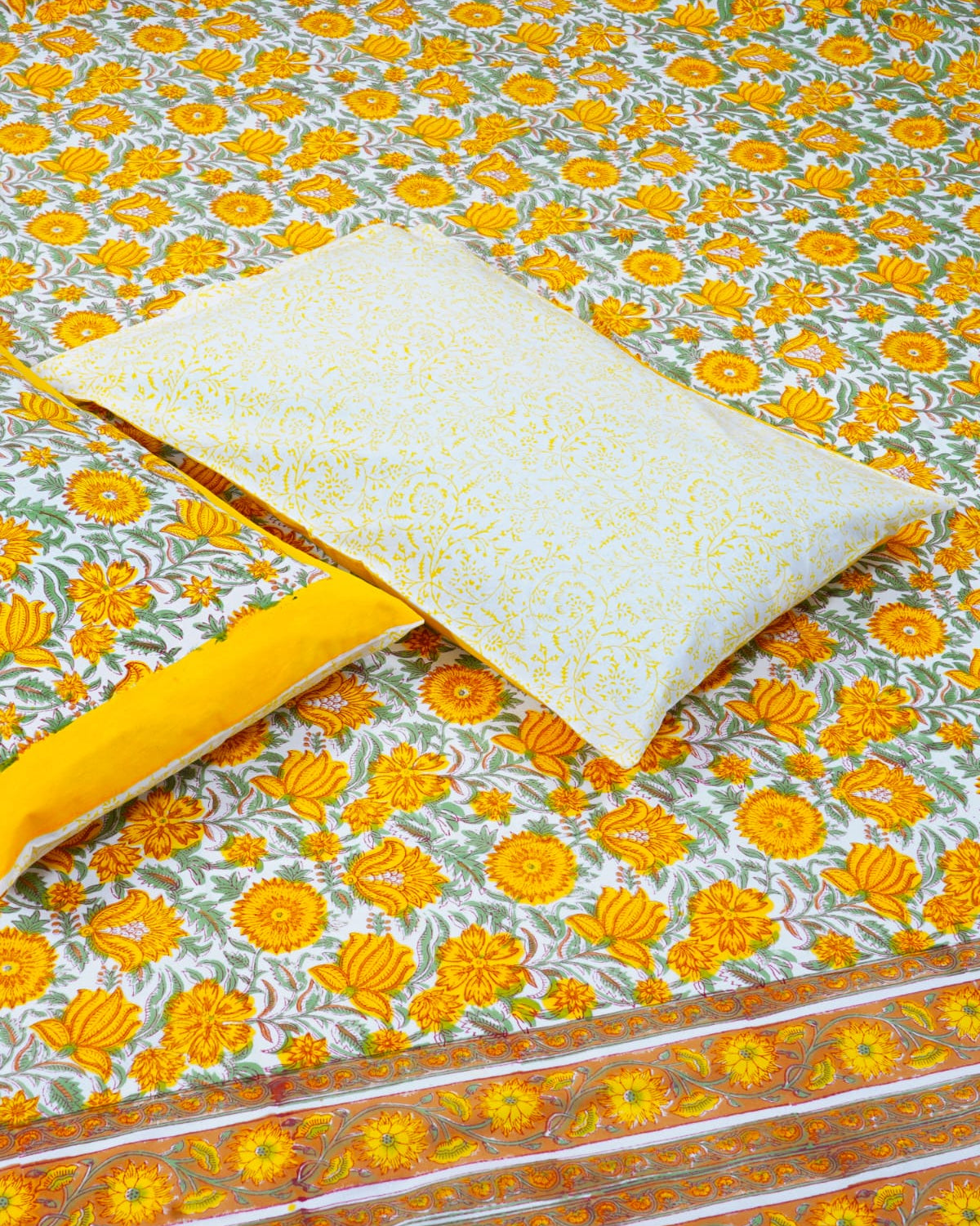 100x108 inch king size cotton bedsheet and matching pillow covers styled with a traditional yellow and green handblock floral print.