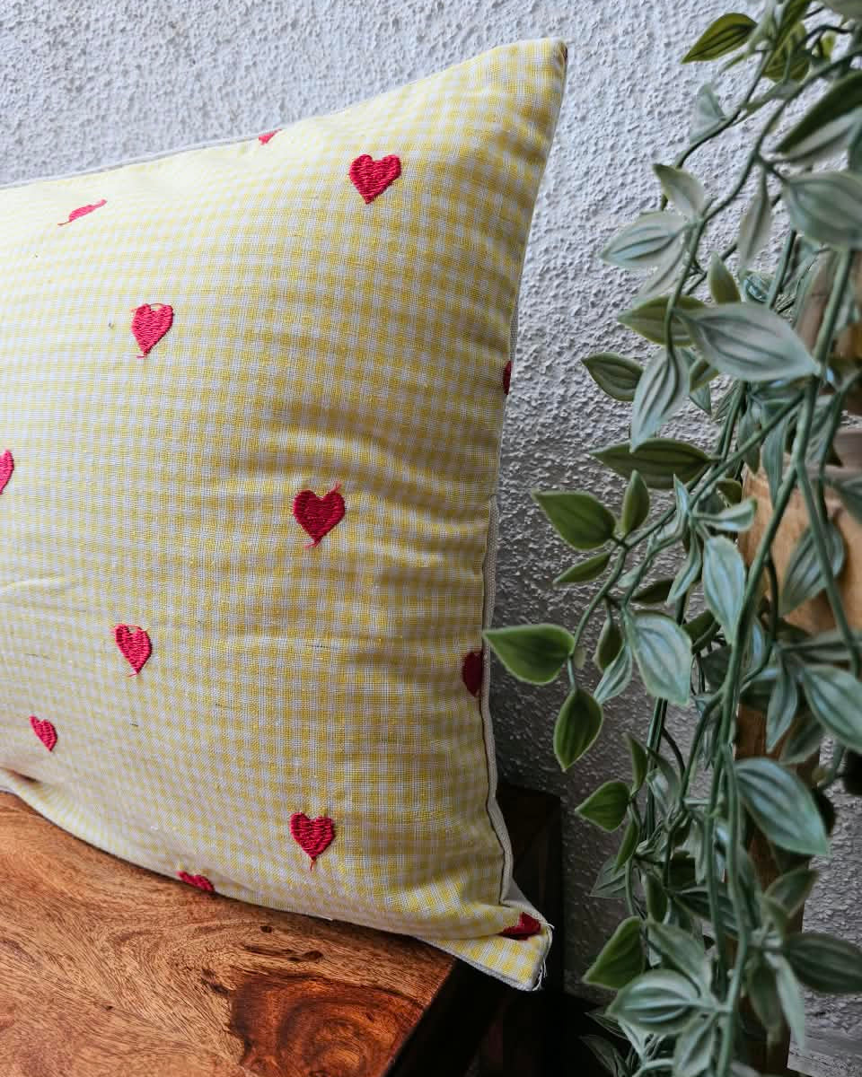 Yellow gingham check cotton cushion cover adorned with charming hand-embroidered red heart motifs.