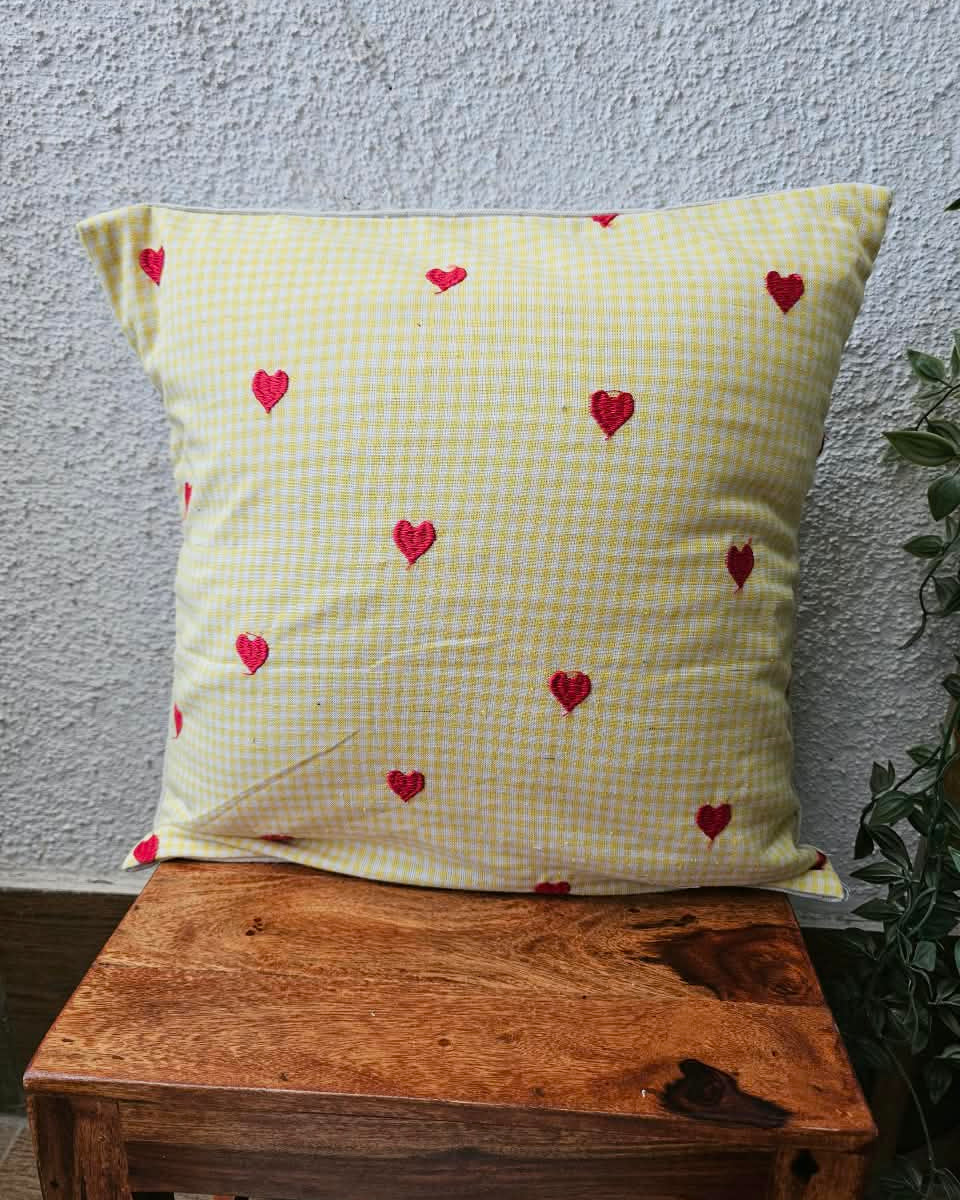 Yellow gingham check cotton cushion cover adorned with charming hand-embroidered red heart motifs.